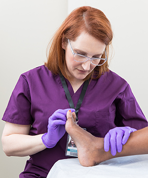 Healthcare provider examining woman's foot.