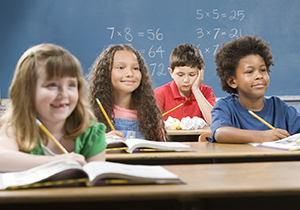 Boy in back of classroom looking distracted.