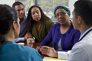 Woman with family members talking to healthcare provider.