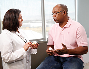 Healthcare provider talking to man in exam room.