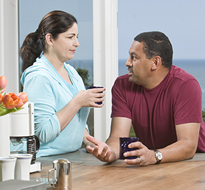 Man and woman in kitchen talking.