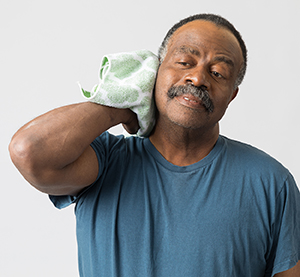 Man holding ice pack on back of neck.