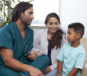 Healthcare provider talking to woman and boy.