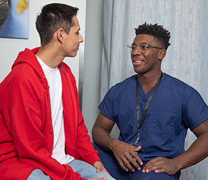 Healthcare provider talking to man in exam room.