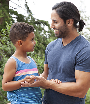 Hombre y niño sonrientes al aire libre.