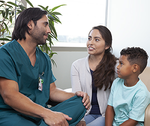 Health care provider talking to woman and boy.